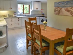 a kitchen with a wooden table and chairs at Swallowdale in Flordon