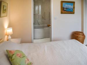 a bedroom with a bed and a bathroom with a tub at Swallowdale in Flordon +15 photos