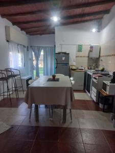 a kitchen with a table in the middle of a room at DPTO con PARQUE, PARRILLA y PISCINA a minutos del centro in Concepción del Uruguay