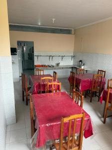a kitchen with tables and chairs with red table cloth at Hotel Solaris in Senhor do Bonfim +9 photos