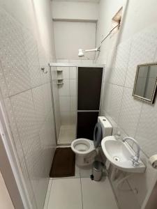 a white bathroom with a toilet and a sink at Hotel Solaris in Senhor do Bonfim