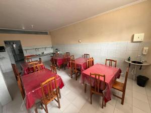 a restaurant with tables and chairs with red table cloth at Hotel Solaris in Senhor do Bonfim