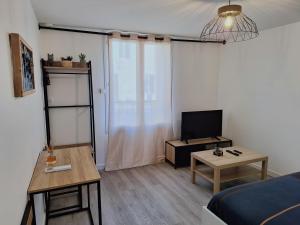 a small room with a bed and a table and a television at Faubourg des voyageurs 4 - Studio climatisé 2 personnes - proche axe autoroute in Saran