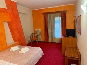 a hotel room with a bed and a television at Driades in Kalavrita