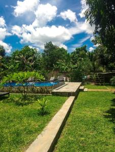 a resort with a swimming pool and green grass at Organic Garden Resort Sigiriya in Sigiriya