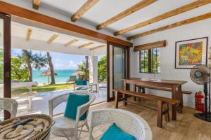 an open living room with a table and chairs and the ocean at BlueMoon Studio on the Beach! in Trou d'Eau Douce