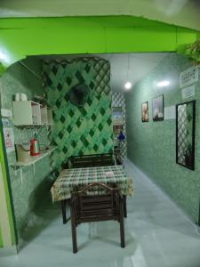 a room with a table and a green wall at Mokdo Guest House in Perhentian Islands
