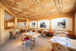 a restaurant with wooden ceilings and tables and chairs at Hotel Corvatsch - Web Check-in in St. Moritz