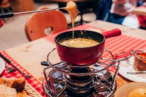 a cup of coffee on a table with a spoon at Hotel Corvatsch - Web Check-in in St. Moritz