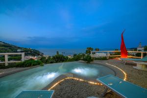 a swimming pool with a view of the ocean at night at Belgodere di Mezzavia Apartments in Lacco Ameno