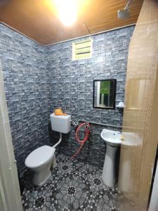 a bathroom with a toilet and a sink and a tv at Mokdo Guest House in Perhentian Islands