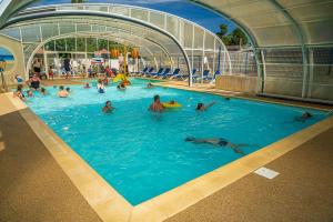 a group of people swimming in a swimming pool at ZEcamping 4 étoiles animé piscine couverte club enfant mini golf dog friendly in La Faute-sur-Mer +16 photos