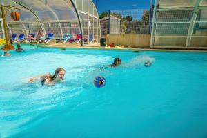 two girls playing in a swimming pool at ZEcamping 4 étoiles animé piscine couverte club enfant mini golf dog friendly in La Faute-sur-Mer