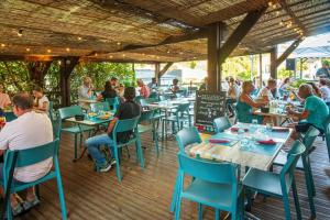 a group of people sitting at tables in a restaurant at ZEcamping 4 étoiles animé piscine couverte club enfant mini golf dog friendly in La Faute-sur-Mer