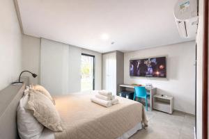 a bedroom with a bed and a desk and a tv at Hotel JD in Taquaritinga do Norte