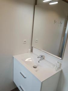 a white bathroom with a sink and a mirror at ZEcamping 3 étoiles animaux acceptés piscine et restaurant in Pluherlin