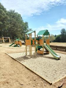 a playground with a slide and an umbrella at ZEcamping 3 étoiles animaux acceptés piscine et restaurant in Pluherlin