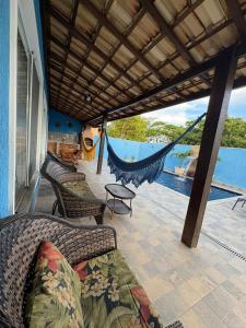 a porch with a hammock and a view of the water at La casa Azul- Búzios in Búzios