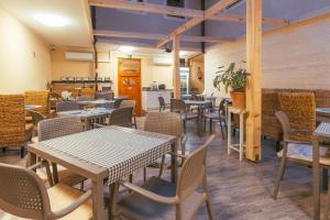 a restaurant with tables and chairs in a room at Végvári Hotel Eger in Eger