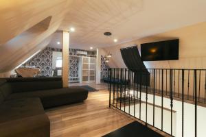 a living room with a couch and a tv on the wall at Végvári Hotel Eger in Eger