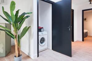a laundry room with a washing machine and a black door at The Vault - Eindhoven - By T&S in Eindhoven +8 photos