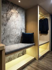 a dressing room with a bench and a stone wall at Metro Hotel in Douliu