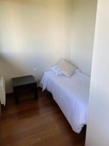 a small bedroom with a bed and a table at Appartement 3 étoiles - eecfga in Saint-Lizier