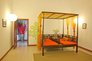 a room with a canopy bed with orange pillows at The Pavilion in Phnom Penh +41 photos