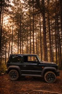 a black jeep parked in the woods at Discovery Compass in Tirana