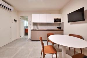 a kitchen with a white table and chairs and a table at Hotel Cortina in Garda +28 photos