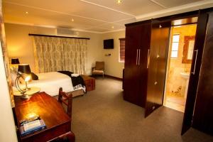 a hotel room with a bed and a desk with a desk at The Black Swann in Queenstown