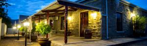 a building with plants outside of it at night at The Black Swann in Queenstown