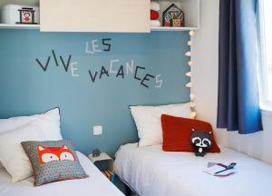 a bedroom with a bed with a blue wall at ZEcamping 4 étoiles 500m plage piscine couverte animaux acceptés club enfant in Sérignan