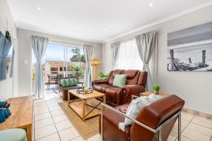 a living room with a couch and a table at Coral Grove in Strand