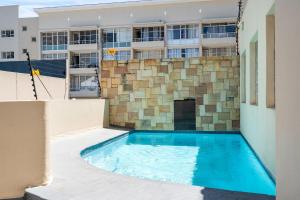 a swimming pool in front of a building at Coral Grove in Strand