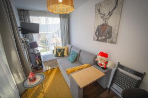 a living room with a teddy bear sitting on a couch at Lazy Deer - Camp in Staniszów