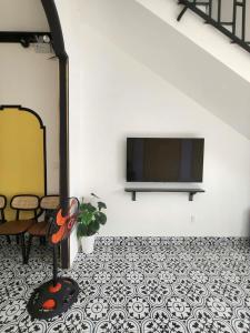 a living room with a flat screen tv on a wall at Villa RonRoy Hà Tiên in Hà Tiên