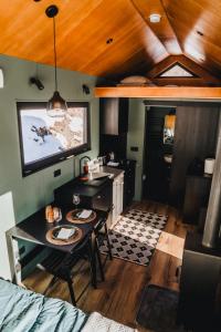 a room with a kitchen with a table and a tv at TogetherNest - Ash in Mătişeşti