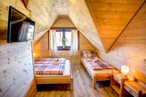 a room with two beds in a wooden cabin at Drevenica pod Sitieňom 2 in Svätý Kríž +38 photos