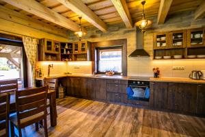 a large kitchen with wooden floors and wooden ceilings at Drevenica pod Sitieňom 2 in Svätý Kríž