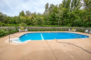a swimming pool with chairs and a fence at On River Time Bring Your Pup Pool in Bartlett