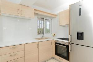 a kitchen with wooden cabinets and a refrigerator at Livingstone House in Porto Rafti +28 photos
