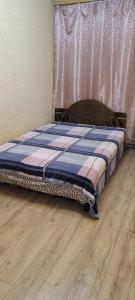 a bed in a room with a wooden floor at 12 Квартал Шинник in Dnipro