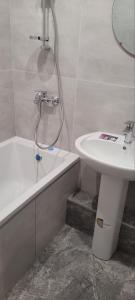 a bathroom with a sink and a bath tub and a toilet at 12 Квартал Шинник in Dnipro