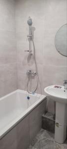 a bathroom with a bath tub and a sink at 12 Квартал Шинник in Dnipro