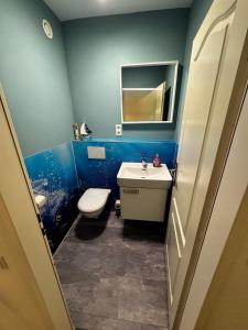 a blue bathroom with a toilet and a sink at Ferienwohnung Deichblick in Bremerhaven