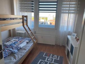 a small bedroom with a bunk bed and a window at Ferienwohnung Deichblick in Bremerhaven