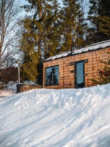 a small brick building in the snow at TogetherNest - Cedar in Mătişeşti