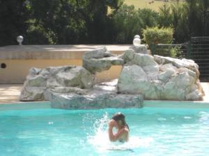 a woman in the water in a swimming pool at ZEcamping 4 étoiles animaux acceptés tennis pataugeoire in Tamniès +19 photos