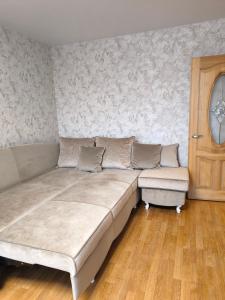 a couch and a chair in a room at Debreceno apartamentai in Klaipėda